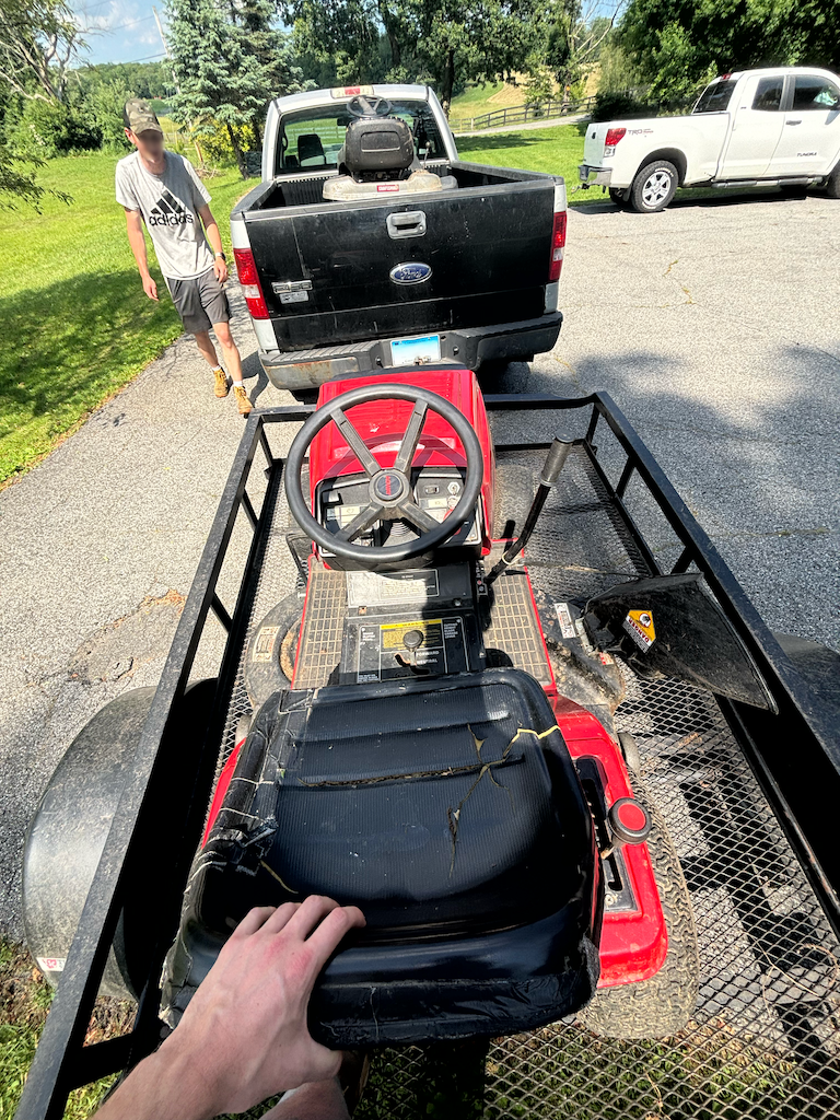 Both lawnmowers secured on the truck and trailer