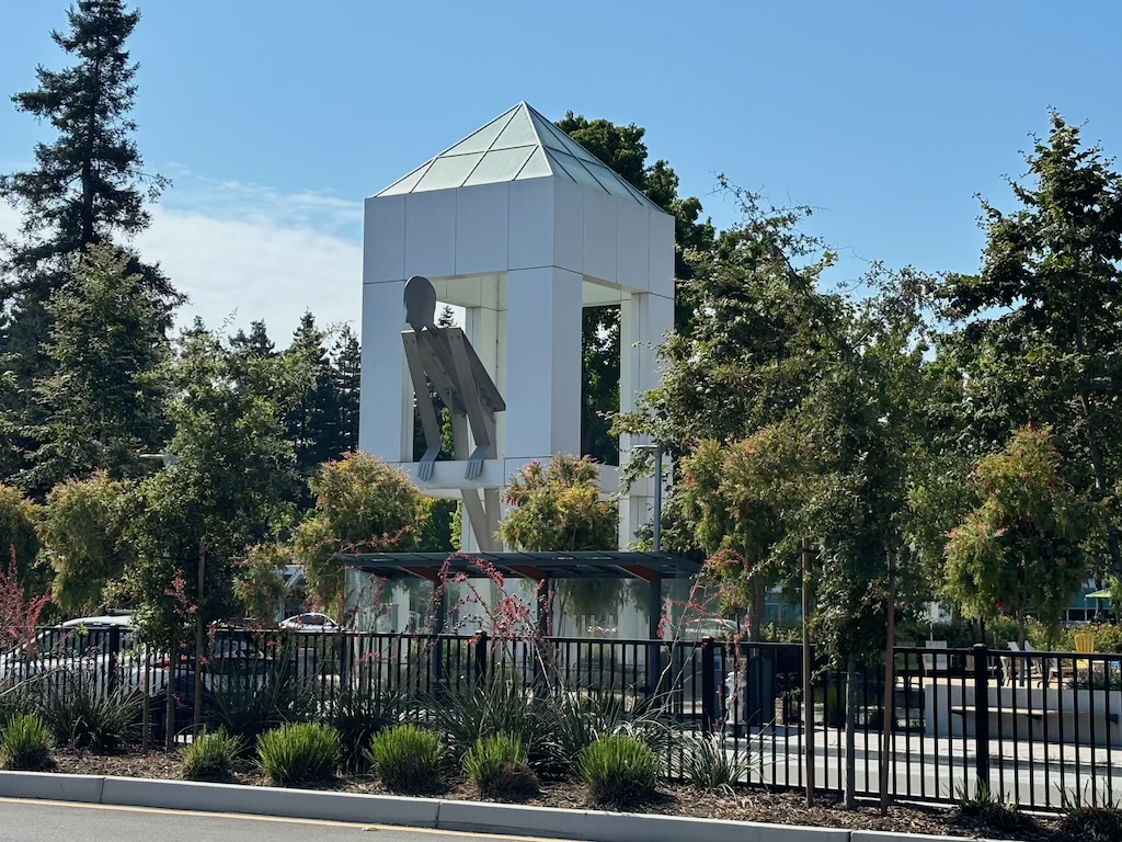 Large man leaning out of window sculpture